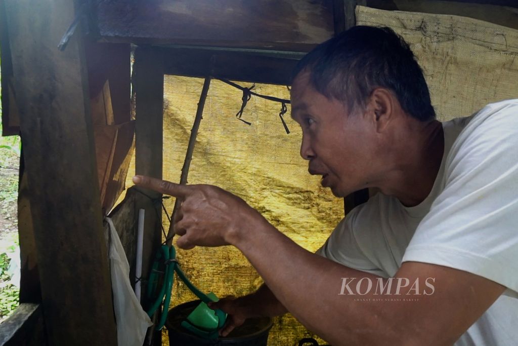 Sudir Tanda (52) menunjukkan air yang tak pernah berhenti mengalir di kamar mandi rumahnya di Dusun II Desa Mengkang, Kecamatan Lolayan, Bolaang Mongondow, Sulawesi Utara, Sabtu (16/7/2022).