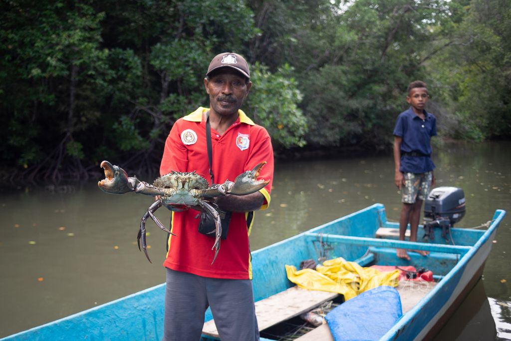 Lalisi Ritarita menunjukkan kepiting bakau yang berhasil ditangkap di hutan mangrove dekat Kampung Mandoni, Distrik Kokas, Kabupaten Fakfak, Papua Barat, Selasa (27/6/2023). Ia memperkirakan kepiting itu beratnya sekitar 2 kilogram.