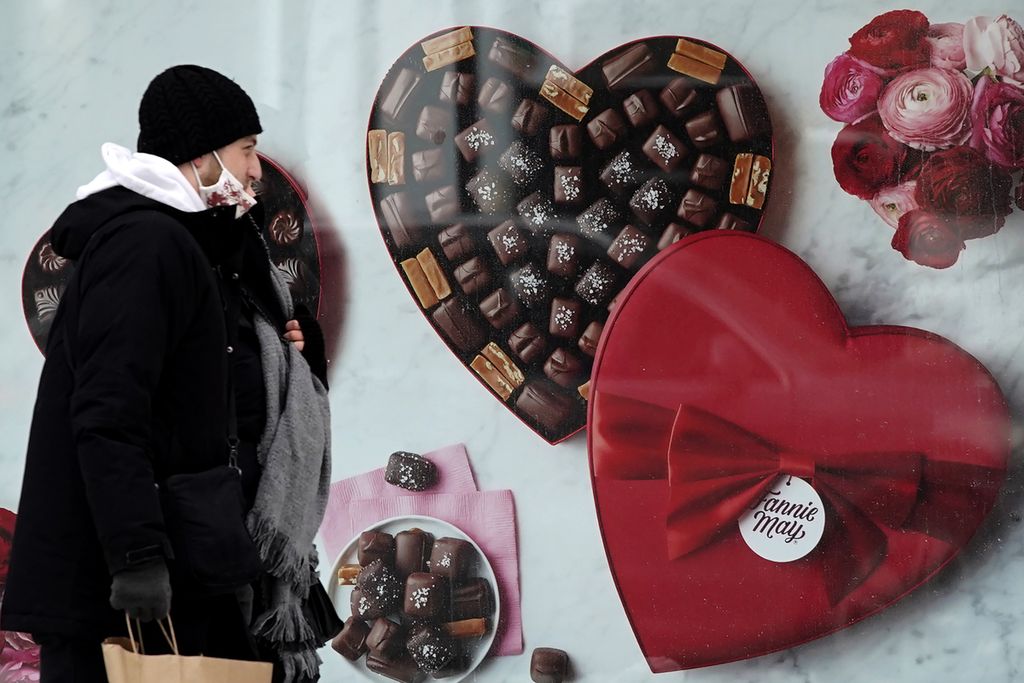 Seorang laki-laki melewati toko cokelat Fannie May di pusat kota Chicago, AS, pada Hari Valentine, Rabu (14/2/2021). 