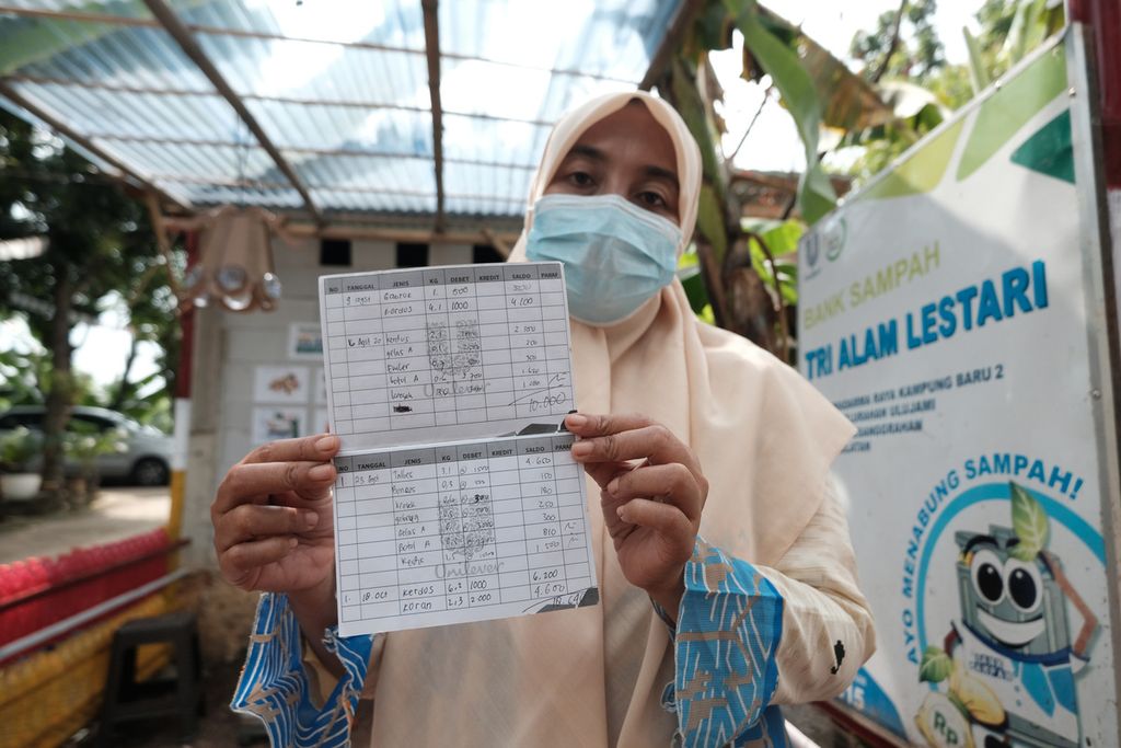 Umi Haniah (46) menunjukkan buku tabungan miliknya di Bank Sampah Tri Alam Lestari, Pesanggrahan, Jakarta, Kamis (6/10/2022).