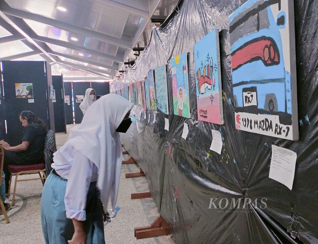 Seorang pengunjung, siswa SMK asal Yogyakarta, mencermati salah satu lukisan karya anak yang dipajang dalam pameran bertajuk "Merdeka Menggambar" yang digelar di Museum BPK-RI, Kota Magelang, Jawa Tengah, Selasa (22/8/2023).