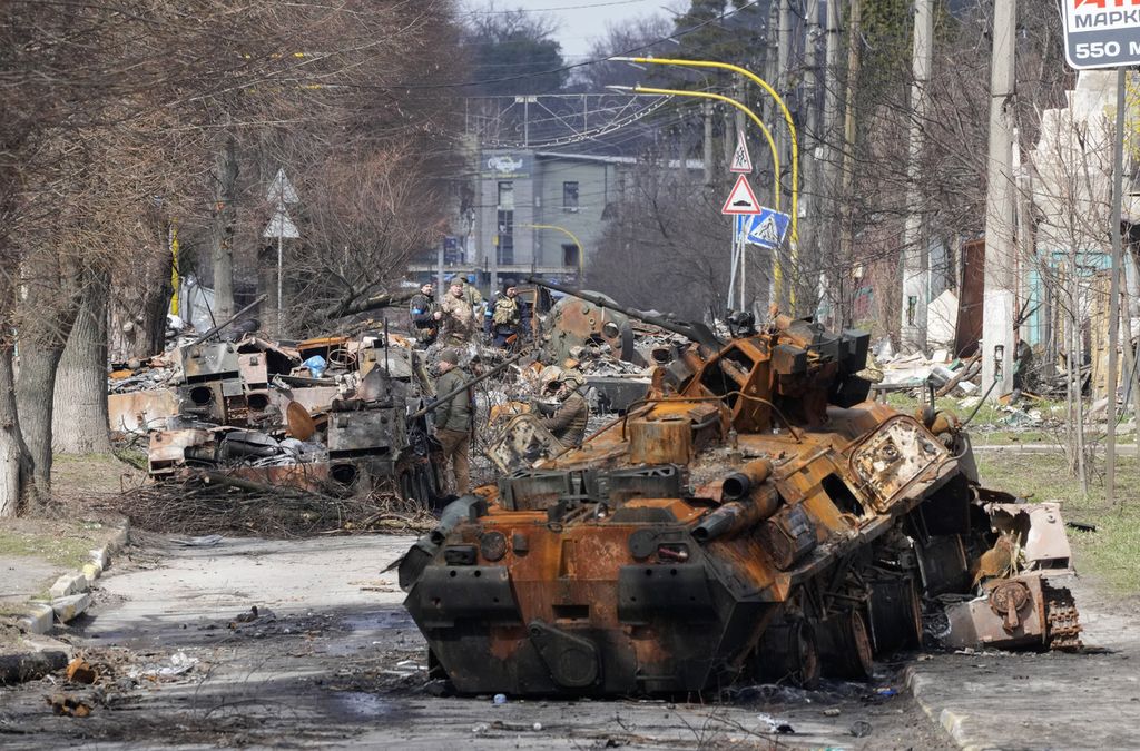 Tentara Ukraina memeriksa kendaraan militer Rusia yang hancur di Bucha, Ukraina, 4 April 2022. 