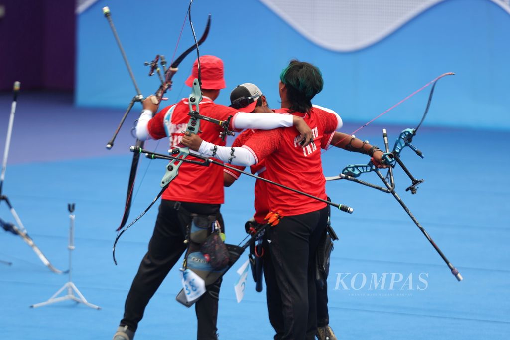The Indonesian archery team, Riau Ega Agatha Salsabilla/Arif Dwi Pangestu/Ahmad Khoirul Baasith (from left to right), embrace after winning the match against Bangladesh in the bronze medal match for the men's team recurve number at the 2022 Asian Games at Fuyang Yinhu Sports Center, Zhejiang Province, China, Friday (6/10/2023).