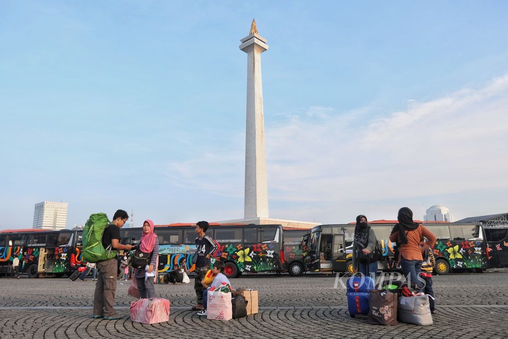 Pemudik yang mengikuti program mudik gratis mencari bus tujuan mereka di kawasan Monas, Jakarta, Kamis (4/4/2024). Monas adalah salah satu ikon Jakarta. 