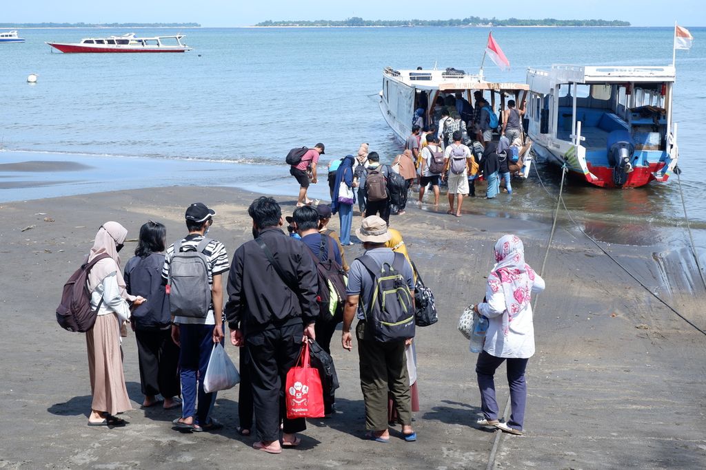 Wisatawan yang baru selesai berlibur di Gili Trawangan, Desa Gili Indah, Kecamatan Pemenang, Kabupaten Lombok Utara, Nusa Tenggara Barat, tiba di Pelabuhan Bangsal, Minggu (26/12/2021). 
