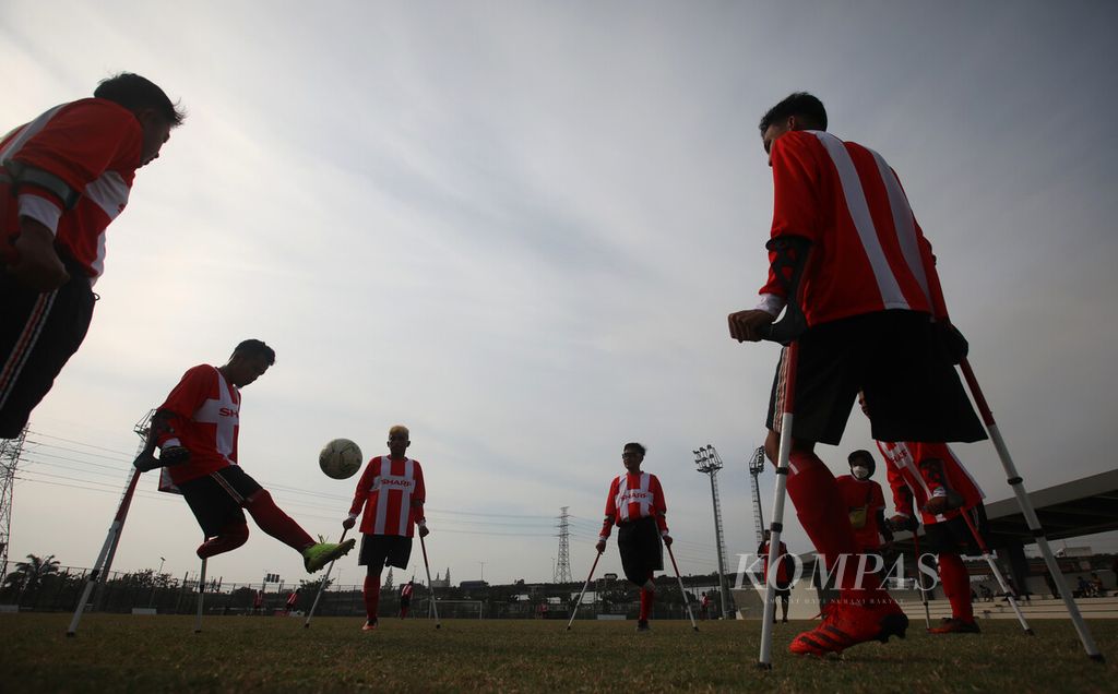 Anggota timnas Perkumpulan Sepakbola Amputasi Indonesia (PSAI) melakukan pemanasan sebelum berlatih tanding dengan tim Garuda Keadilan FC di lapangan latih kompleks Jakarta International Stadium, Rabu (30/3/2022). 