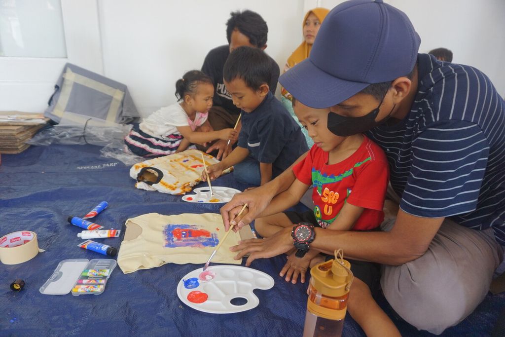 Anak-anak didampingi orangtuanya antusias melukis pada kaus di Heterospace, di Purwokerto, Minggu (2/4/2023).