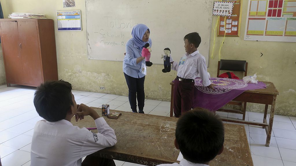 Salah seorang profesional berbagi kisah soal profesi bidang teknologi informasi dengan alat peraga boneka di SDN Kebalen, Pulau Panjang, Kabupaten Serang, Banten. Anak-anak di pulau-pulau kecil itu diberi inspirasi untuk mengenal beragam profesi.