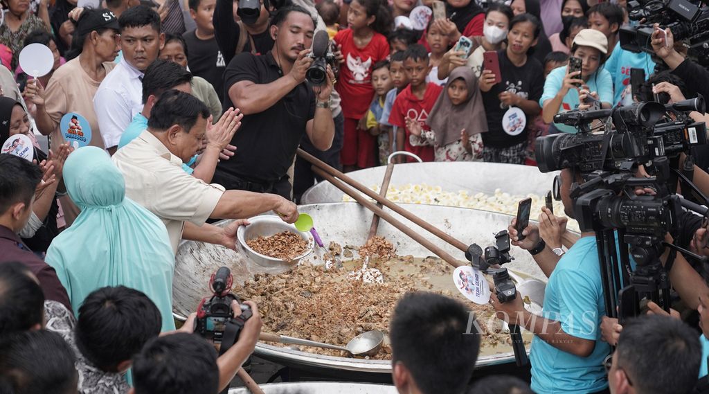 Calon presiden Prabowo Subianto menambahkan potongan daging pada masakan opor ayam dalam wajan raksasa saat berkampanye di Saung Kita, Cilincing, Jakarta Utara, Jumat (8/12/2023). Kampanye calon presiden nomor urut 2 ini diisi dengan acara Makan Besar, yaitu menyediakan makan siang bagi warga setempat yang hadir dalam kampanyenya. 