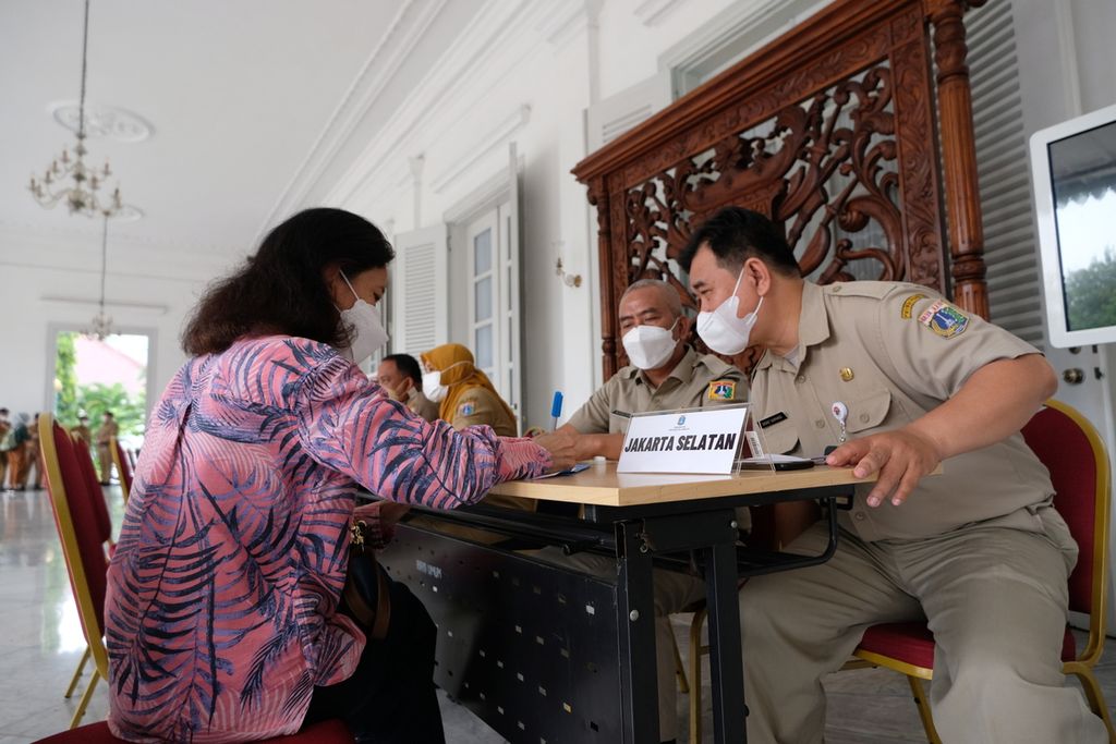 Petugas pelayanan membantu warga untuk mengisi formulir di pendopo Balai Kota DKI Jakarta, Selasa (18/10/2022). Pelayanan pengaduan masyarakat di pendopo Balai Kota DKI Jakarta kembali dibuka setelah berpindah menuju ke kecamatan dan kelurahan pada kepemimpinan Anies Baswedan. Pelayanan pengaduan masyarakat ini dibuka pada hari Senin sampai Jumat dari pukul 07.30 sampai pukul 09.30. 