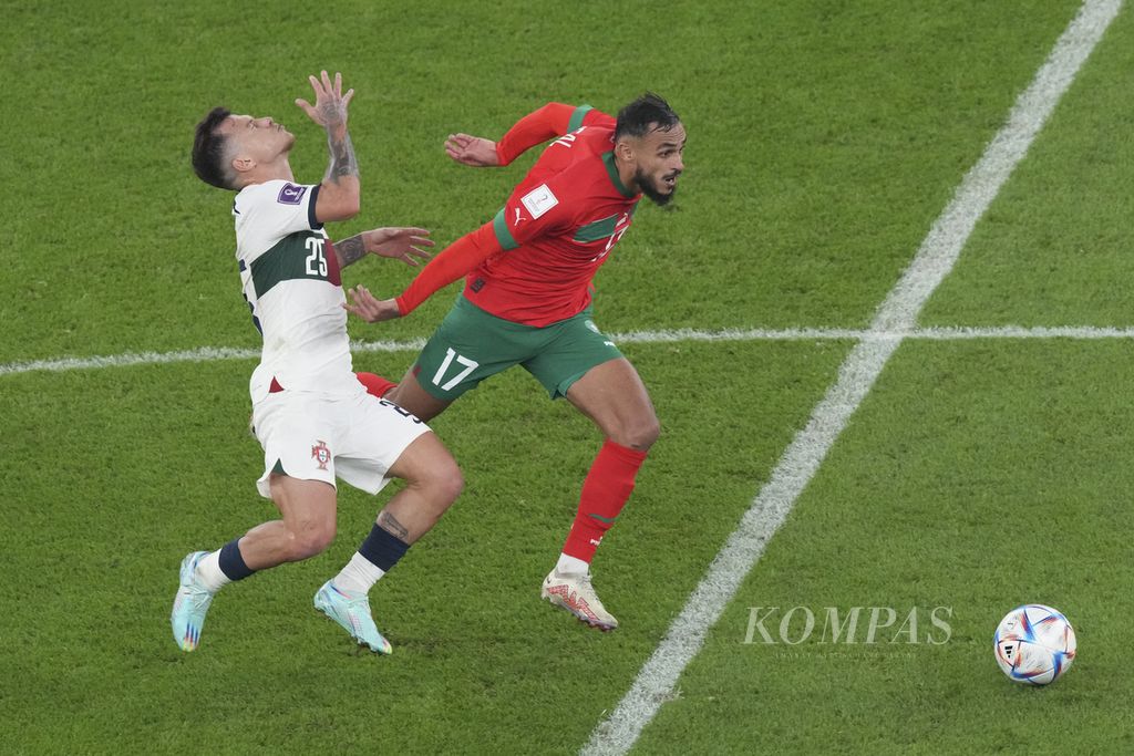 Pemain Portugal Otavio (kiri) berebut bola dengan pemain Maroko Sofiane Boufal di babak perempat final Piala Dunia 2022 di Stadion Al Thumama, Qatar, Sabtu (10/12/2022).