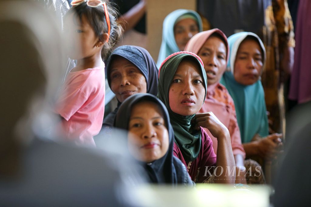 Warga menunggu pembagian beras di Kantor Desa Pringgasela Selatan, Kecamatan Pringgasela, Kabupaten Lombok Timur, Nusa Tenggara Barat, Senin (18/12/2023). Mereka yang menerima bantuan sosial nontunai ini merupakan keluarga penerima manfaat Program Keluarga Harapan (PKH). Setiap penerima mendapatkan bantuan beras 10 kilogram. 