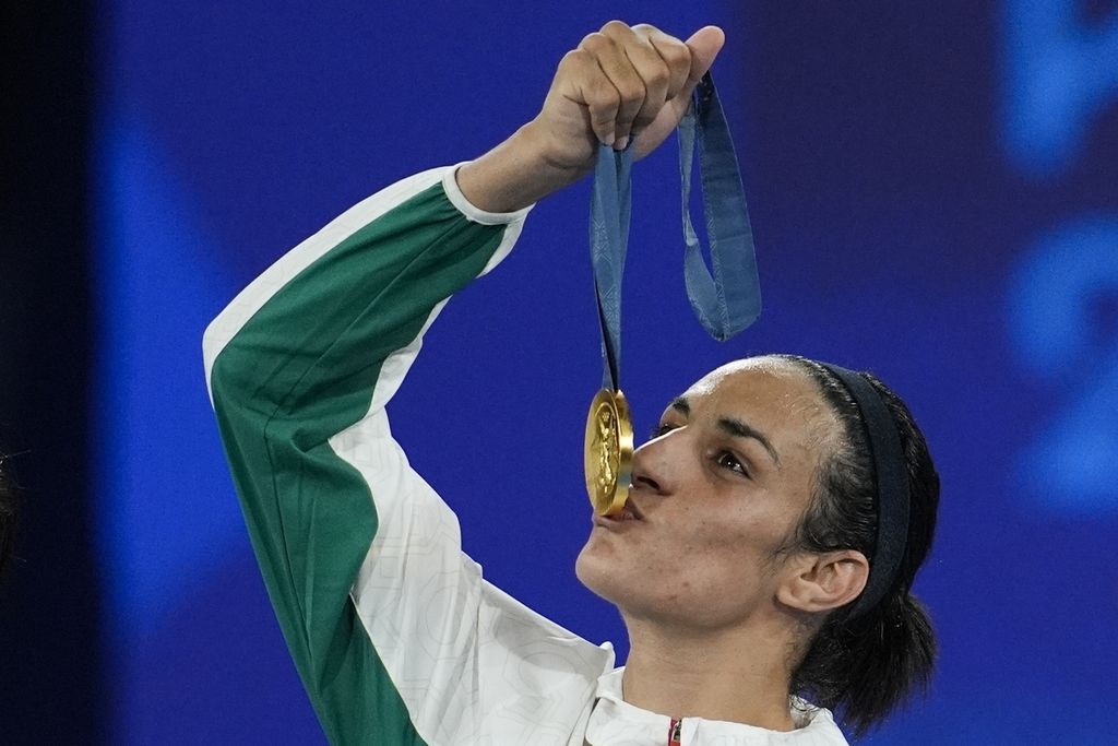 Petinju Aljazair, Imane Khelif, mencium medali emas Olimpiade seusai mengalahkan Yang Liu (China) pada final tinju nomor 66 kilogram putri Olimpiade Paris, Sabtu (10/8/2024), di Perancis. Khelif menang dengan nilai mutlak.