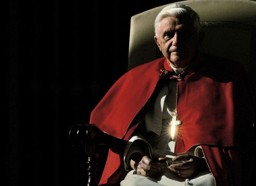 Foto yang diambil pada 7 Desember 2005 ini memperlihatkan salib di dada Paus Benediktus XVI memantulkan cahaya matahari saat Paus menghadiri audiensi mingguan di alun-alun Santo Petrus di Vatikan. 