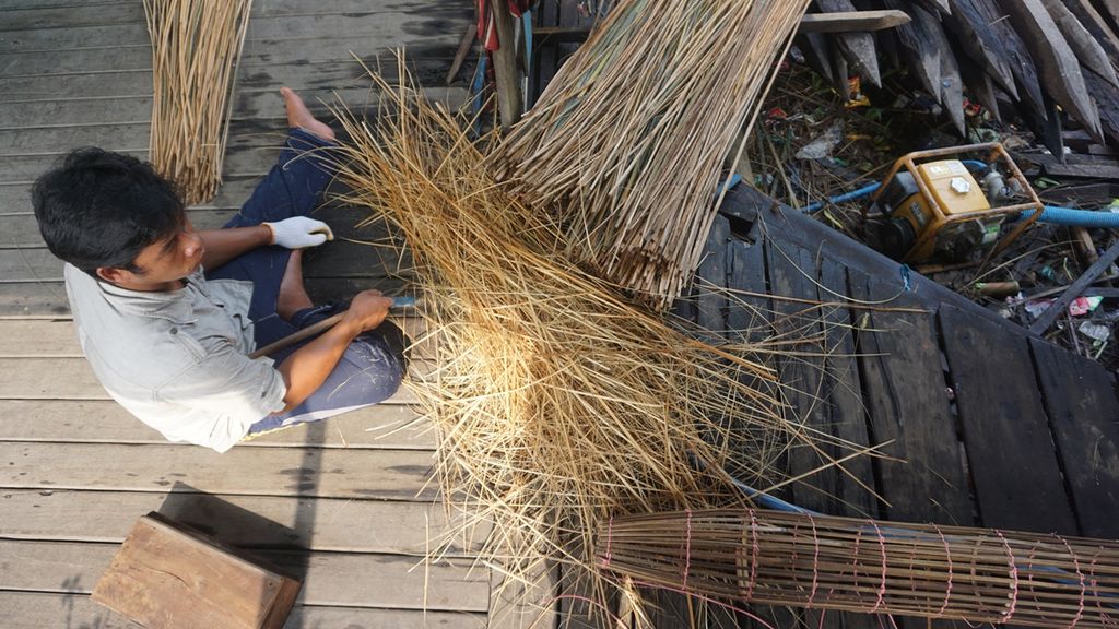 Ujang (31), salah satu nelayan di Desa Paduran Sebangau, Kabupaten Pulang Pisau, Kalteng, sedang membuat bubu atau alat tangkap ikan tradisional, Minggu (10/11/2019).