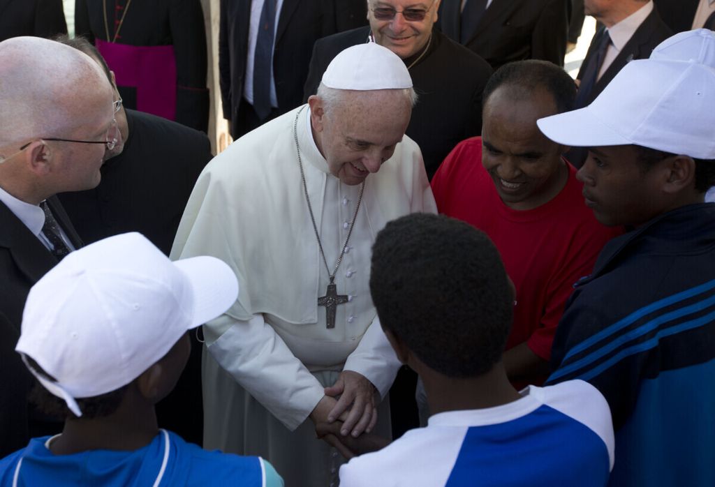 Arsip foto pada 8 Juli 2013 memperlihatkan Paus Fransiskus berbicara kepada para migran, beberapa mengenakan topi putih, saat berkunjung ke Lampedusa, Italia selatan. 