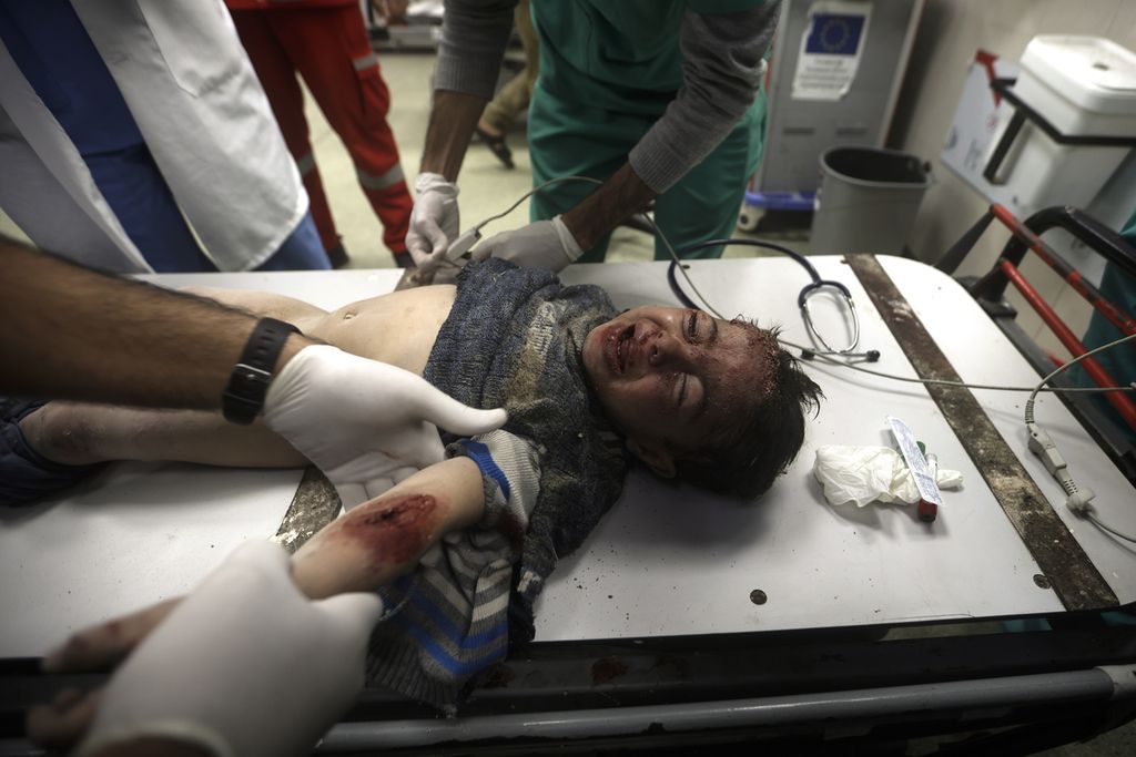 Petugas medis memberikan pengobatan kepada seorang anak yang terluka akibat serangan Israel di Rumah Sakit Nasser, Khan Younis, Jalur Gaza, Jumat (29/12/2023). Serangan Israel telah menewaskan lebih dari 21.000 warga Palestina di Jalur Gaza.