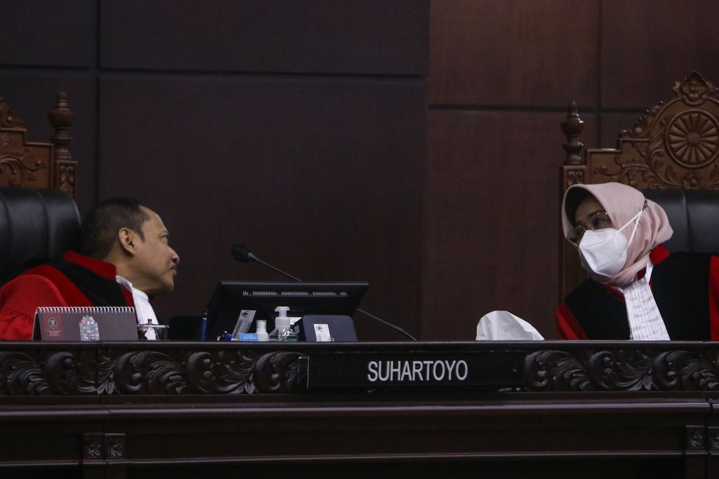 Hakim Konstitusi Suhartoyo berbincang dengan Hakim Konstitusi Enny Nurbaningsih dalam sidang pleno di Gedung Mahkamah Konstitusi, Jakarta, Kamis (26/1/2023).