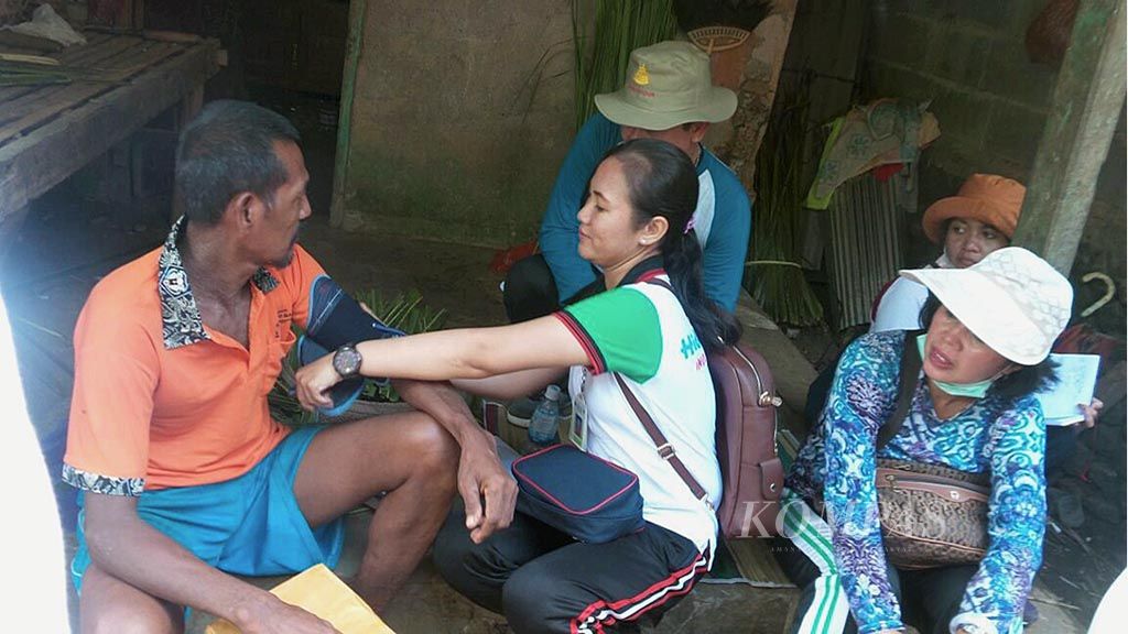  Petugas Puskesmas Desa Gunaksa, Kabupaten Klungkung, Bali, sedang memeriksa kesehatan seorang warga miskin di desa itu.