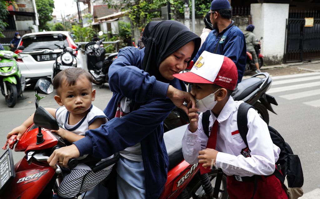 Seorang siswa berpamitan kepada ibunya saat tiba di SD Negeri Joglo 05, Kembangan, Jakarta Barat, Senin (30/1/2023)
