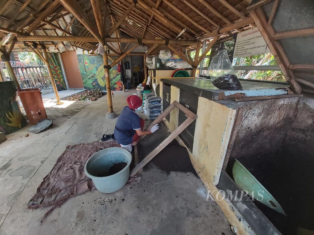 Pekerja di bank sampah Akkom Jakarta sedang mengayak hasil <i>composting</i> sampah organik yang sudah menjadi kompos organik siap pakai.