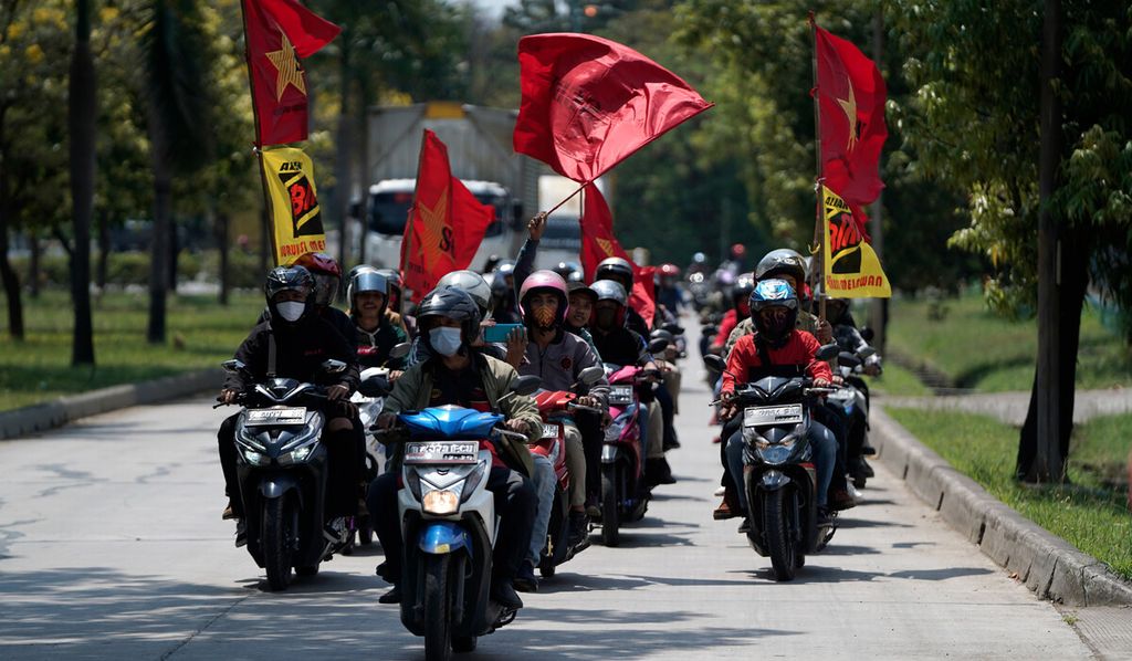 Buruh arak-arakan keliling naik sepeda motor di kawasan Bekasi International Industrial Estate, Cikarang Selatan, Kabupaten Bekasi, Jawa Barat, Rabu (7/10/2020). 
