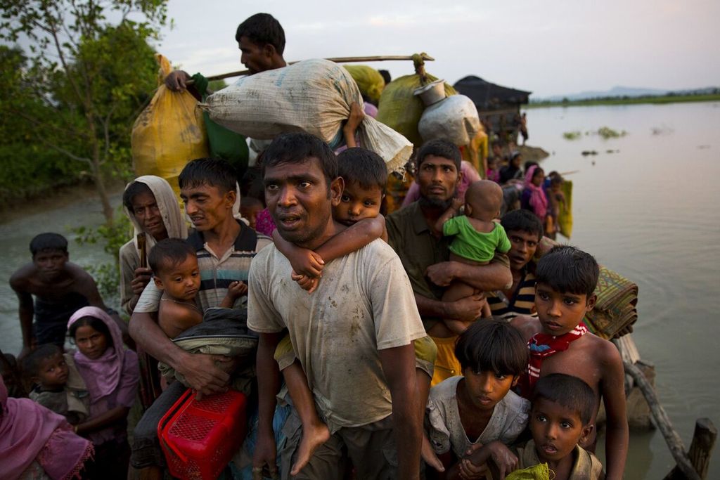 Arsip foto menunjukkan warga Rohingya menggendong anak-anak dan barang-barang milik mereka setelah menyeberangi perbatasan dari Myanmar menuju Bangladesh, dekat Palong Khali, Bangladesh, 1 November 2017. 