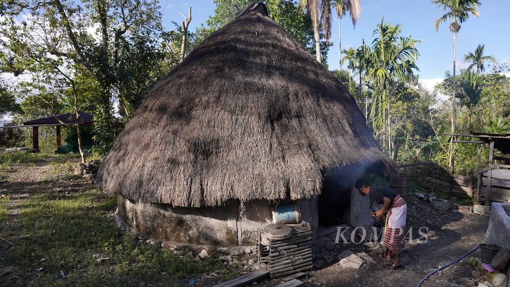 Tony Oematan (29), anggota Lakoat.Kujawas, memeriksa umay bubu atau rumah tradisional yang digunakan untuk menyimpan pangan lokal di Desa Taifob, Kecamatan Mollo Utara, Kabupaten Timor Tengah Selatan, NTT, Sabtu (5/8/2023). Riset, pengarsipan pengetahuan lokal, eksperimen di <i>foodlab</i> dan memperkenalkan kekayaan rasa dan manfaat pangan lokal ke lidah anak-anak dilakukan komunitas ini sembari berkampanye pangan lokal sehat bernutrisi untuk keluarga.