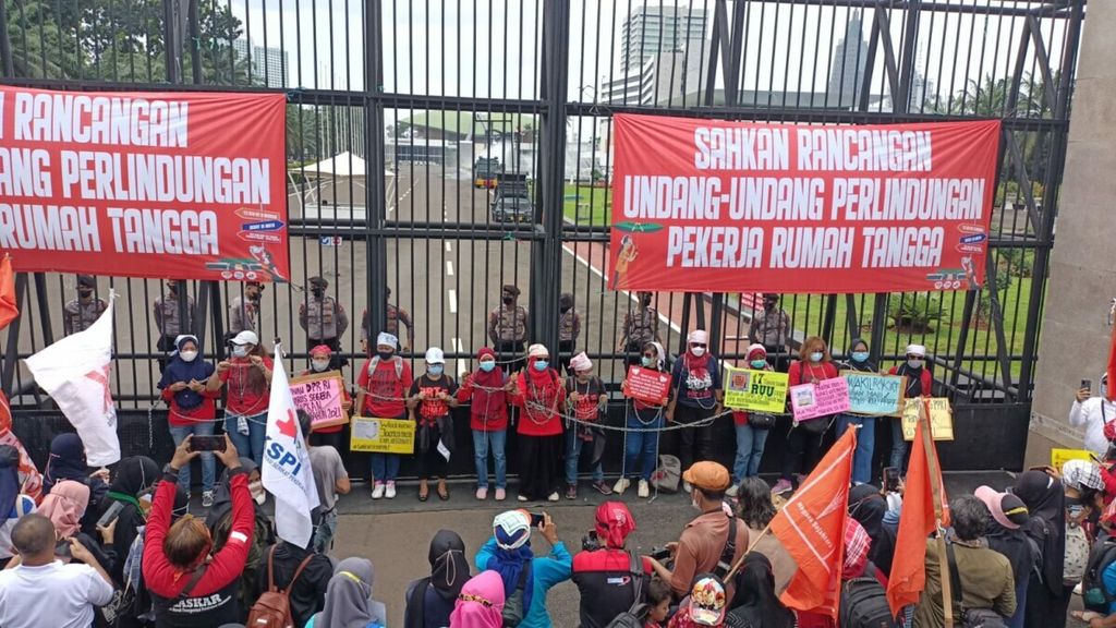 Sejumlah pekerja rumah tangga, Selasa (14/12/2021), menggelar aksi di depan Gedung MPR/DPR/DPD, Senayan, Jakarta, dengan cara merantai diri bersama-sama seraya menyampaikan orasi kepada para wakil rakyat. Mereka mendesak DPR segera membahas dan mengesahkan RUU PPRT.