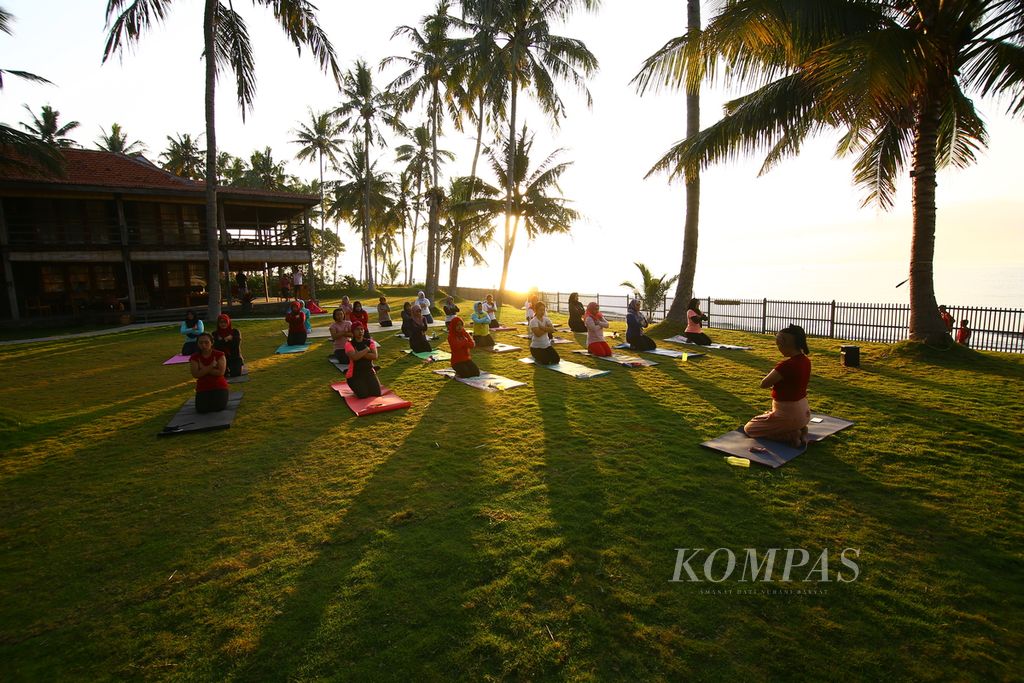 Wisatawan dan penggemar yoga menikmati hangatnya matahari terbit dan kesejukan udara pesisir Selat Bali ketika Sun Rise Yoga di Villa So Long, Banyuwangi, Minggu (10/8/2020). 