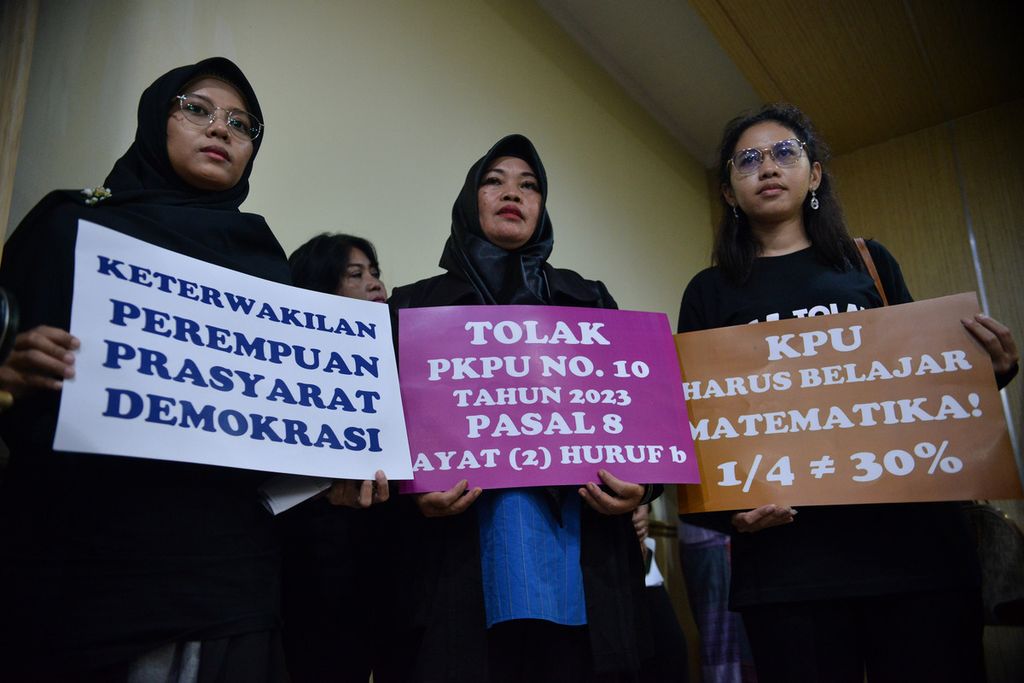 Peserta aksi membawa poster penolakan Peraturan Komisi Pemilihan Umum Nomor 10 Pasal 8 saat sesi konferensi pers di kompleks Badan Pengawas Pemilu, Jakarta Pusat, Senin (8/4/2023). 