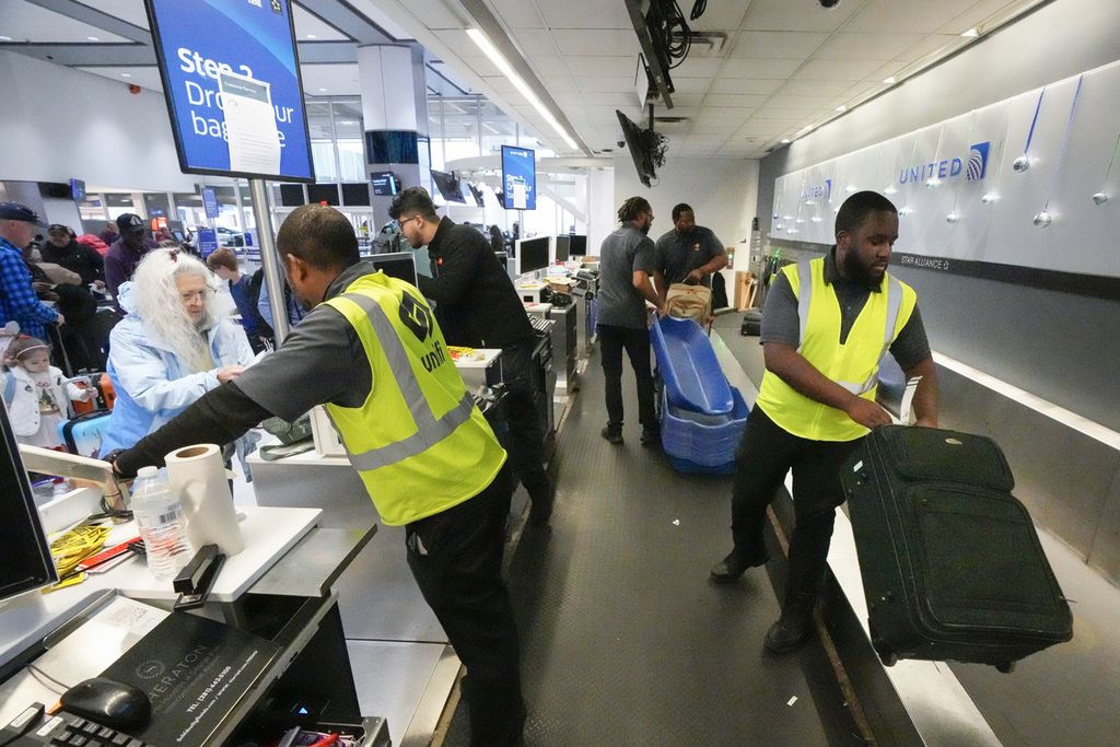 Passengers hand over baggage to officers at George Bush Intercontinental Airport in Houston, Texas, December 2023.