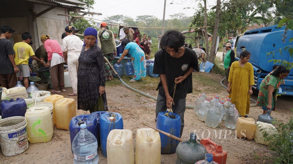 Warga bersiap membawa air bersih yang didistribusikan Markas Bersama Assunnah di Kampung Cihanjuang, Desa Ridogalih, Kecamatan Cibarusah, Kabupaten Bekasi, Jawa Barat, Minggu (10/9/2023). 