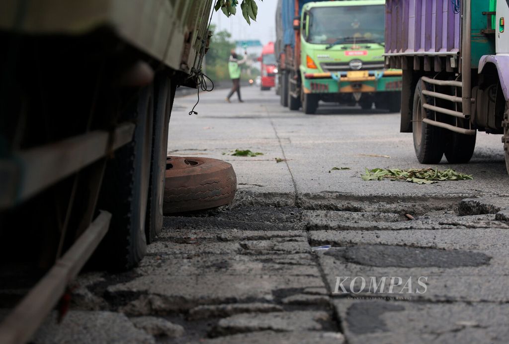 Kerusakan jalan yang menyebabkan sebuah truk mengalami patah pada poros rodanya di Kota Semarang, Jawa Tengah, Kamis (5/1/2023).