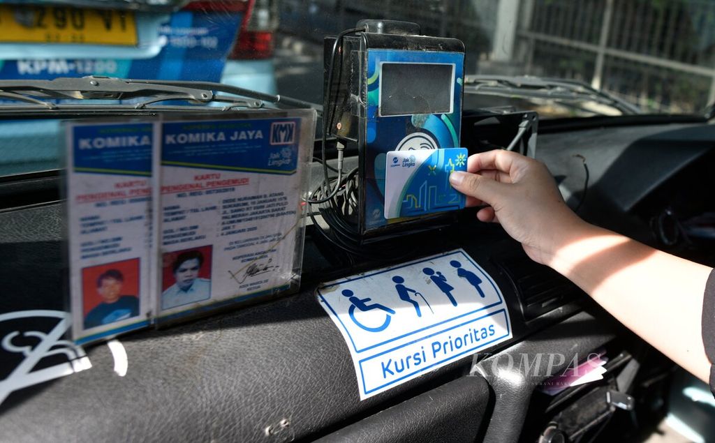 Penumpang menempelkan kartu JakLingko pada alat pembaca kartu JakLingko saat menaiki angkot JakLingko dari Stasiun Tanah Abang, Jakarta Pusat, Rabu (15/1/2020). 