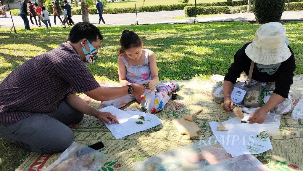 Seorang anak berkebangsaan asing (tengah) mencoba membuat <i>ecoprint</i>, mengikuti panduan dari pendampingnya, Sabtu (1/7/2023).