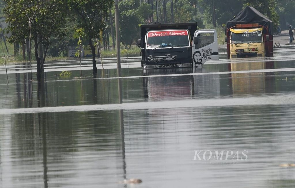 Dua truk mogok akibat tidak bisa melewati banjir di Jalan Raya Porong, Kabupaten Sidoarjo, Jatim, Rabu (17/2/2021). Hujan deras sehari sebelumnya membuat sejumlah kawasan di Sidoarjo terendam banjir. Ketinggian banjir mulai dari 15 sentimeter hingga 80 sentimeter. 