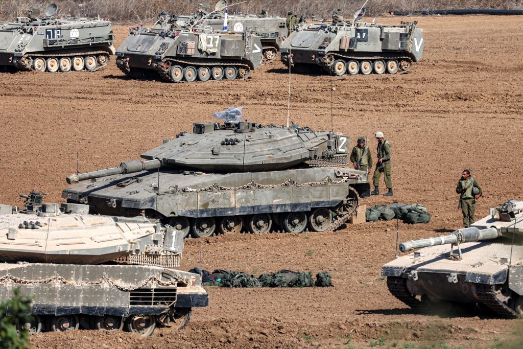 Tank tempur Merkava milik Israel dan kendaraan lainnya dikerahkan di sepanjang perbatasan dengan Jalur Gaza di Israel selatan pada Jumat (13/10/2023).