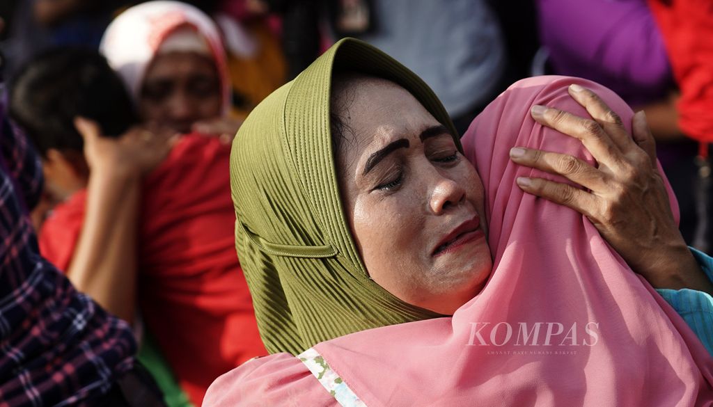 Seorang ibu menangis haru memeluk anaknya. Tangis keharuan para ibu setelah kakinya dicuci anak-anaknya pada saat aksi Cuci Kaki Ibu Massal di Jalan Suryo Pranoto, Petojo, Jakarta, Minggu (18/12/2022). 