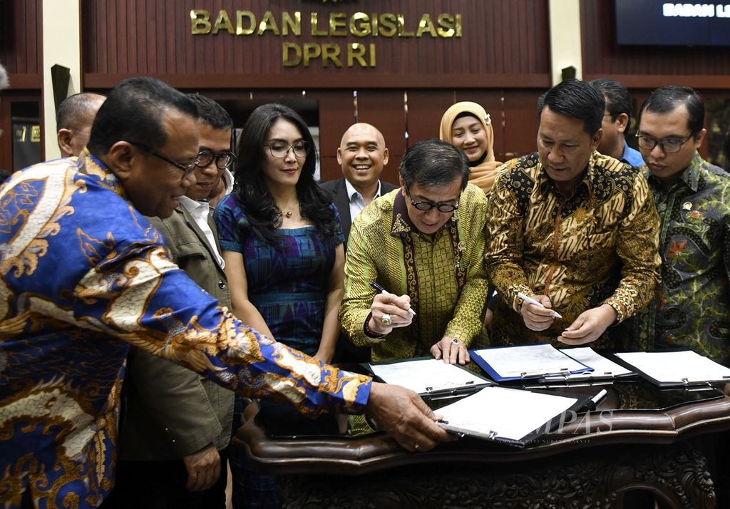 Menteri Hukum dan Hak Asasi Manusia Yasonna Laoly (ketiga dari kanan) didampingi Ketua Badan Legislasi (Beleg) Supratman Andi Agtas (kedua dari kanan) dan Wakil Ketua Baleg Rieke Diah Pitaloka (ketiga dari kiri) menandatangani daftar RUU Prolegnas 2020-2024 dalam Rapat Kerja Penyusunan Prolegnas RUU Tahun 2020-2024 di Gedung Parlemen, Jakarta, 5 Desember 2019.