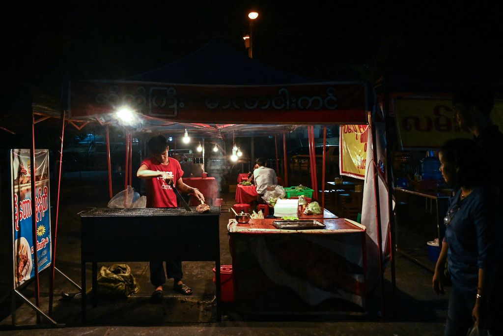 Penjual menyiapkan masakan di sebuah pasar malam, di Naypyidaw, Myanmar, Senin (27/3). 