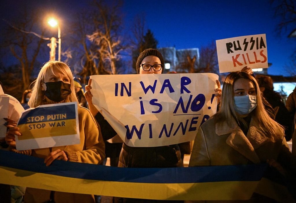 Orang-orang mengambil bagian dalam rapat umum untuk Ukraina di depan Kedutaan Ukraina untuk Romania di Bucharest, Kamis (24/2/2022). Serangan udara menyebabkan banyak bangunan rusak berat.