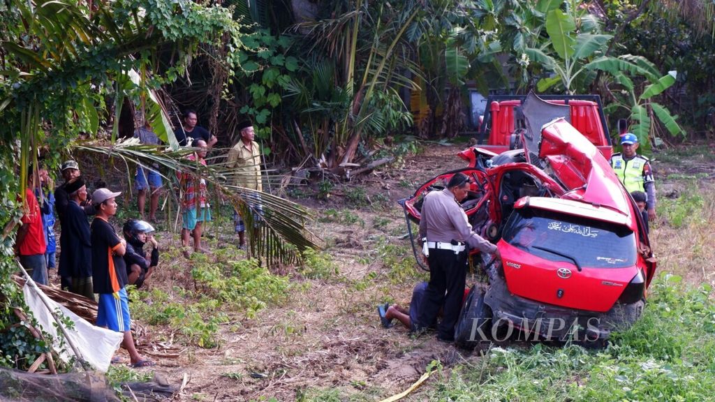Polisi mengamati mobil Toyota Yaris yang ringsek setelah tertabrak kereta api Kaligung relasi Cirebon-Semarang di pelintasan sebidang di Desa Sidorejo, Kabupaten Kendal, Jawa Tengah, Senin (9/12/2019).