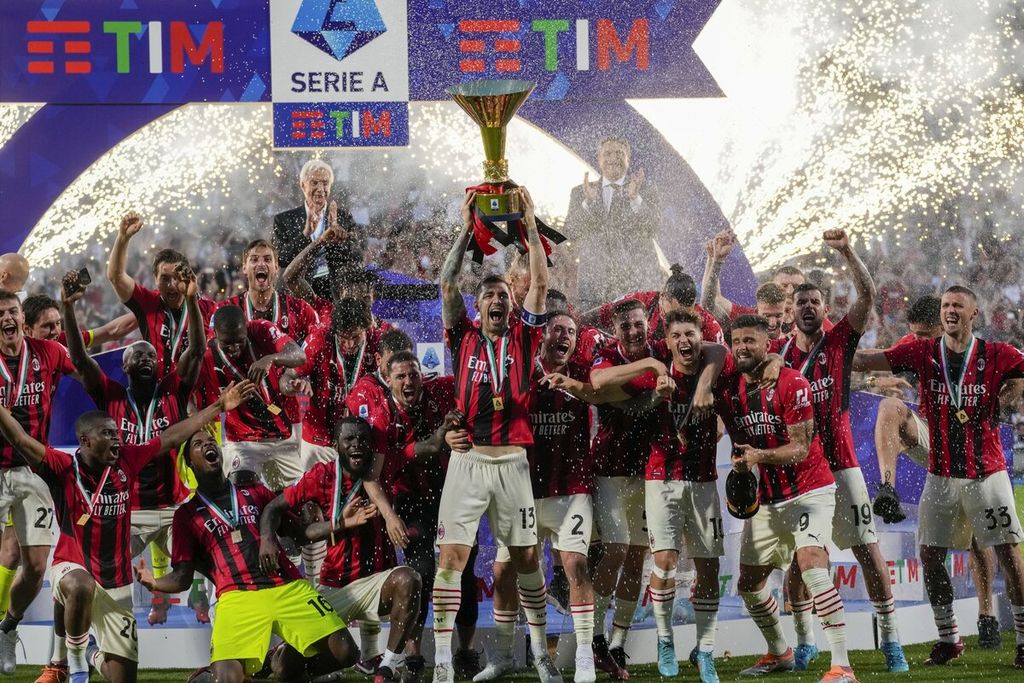 Kapten AC Milan, Alessio Romagnoli, mengangkat trofi juara Liga Italia Serie A saat bersama rekan-rekannya merayakan kesuksesan Milan meraih <i>scudetto</i> seusai laga pekan terakhir melawan Sassuolo di Stadion Mapei, Reggio Emilia, Minggu (22/5/2022). Trofi ini mengakhiri paceklik gelar juara bagi Milan dalam 11 tahun.
