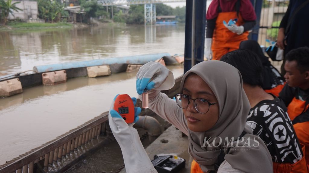 Mahasiswi magang pada Lembaga Kajian Ekologi dan Konservasi Lahan Basah (Ecoton) memperlihatkan hasil pengecekan kandungan besi atau air baku Kali Surabaya di pipa masuk (<i>inlet</i>) Instalasi Penjernihan Air Minum (IPAM) Karangpilang, Surabaya, Jawa Timur, Selasa (21/3/2023). Kandungan oksigen terlarut, amonia, besi, dan fosfor kurang bagus sehingga dalam pengolahan memerlukan upaya ekstra dengan pencampuran tawas dan obat kimia.