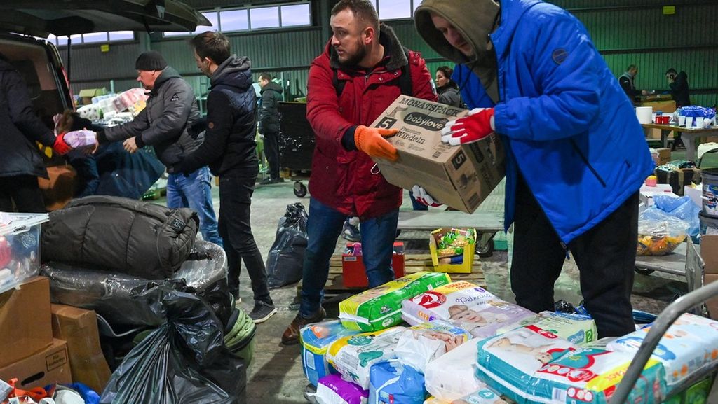 Sukarelawan lokal menurunkan bantuan dari Hongaria dan Ceko dari van di tempat pengumpulan makanan, obat-obatan, dan pakaian di desa Solomonovo, Ukraina,  dekat perbatasan Ukraina-Hongaria, Rabu (2/3/2022). Jumlah pengungsi konflik di Ukraina telah melonjak menjadi hampir 1  juta orang.