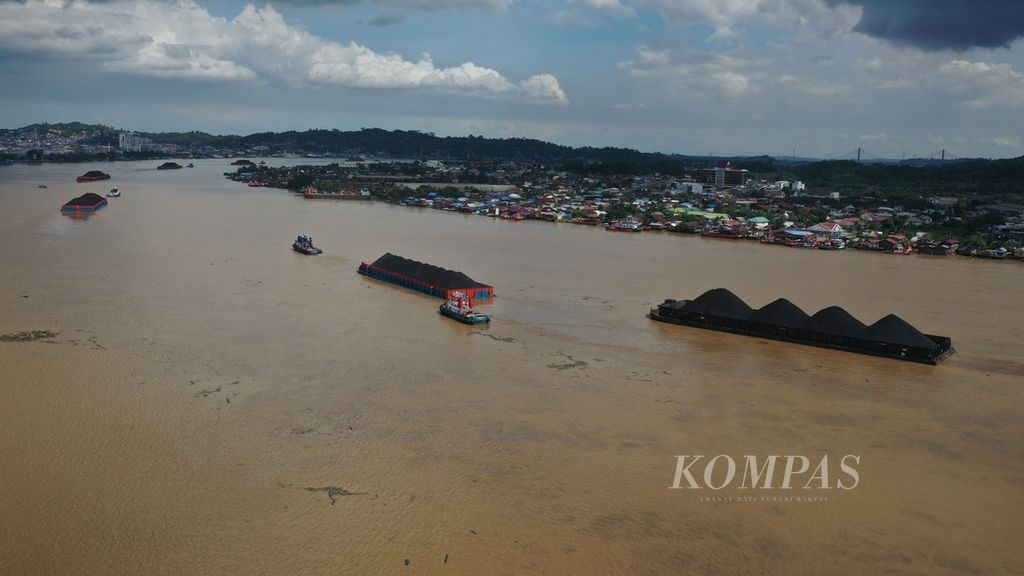 Tongkang yang mengangkut batubara melintas di Sungai Mahakam, di Kota Samarinda, Kalimantan Timur, Senin (25/12/2023).