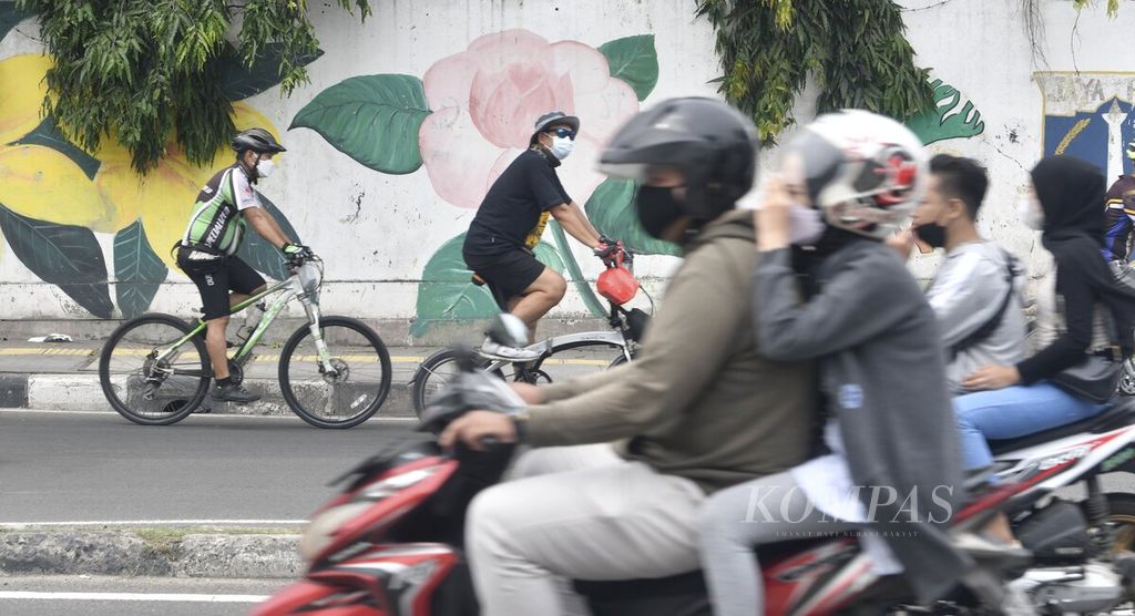 Residents cycle in the Penjaringan area, North Jakarta, Sunday (13/2/2022). This week, PPKM level 3 has been implemented in Jakarta to control the surge in new cases of Covid-19, especially those caused by the Omicron variant. However, residents' discipline to maintain health protocols is still being neglected. 