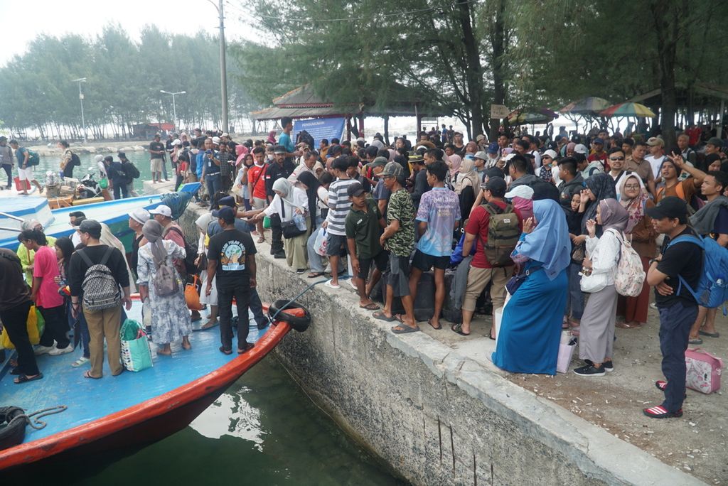 Pengunjung memadati dermaga untuk naik kapal motor masyarakat guna meninggalkan Pulau Pari, Kabupaten Kepulauan Seribu, Jakarta, Senin (1/1/2024). Ada sekitar 2.500 pengunjung yang meninggalkan Pulau Pari menuju Jakarta pada hari itu.