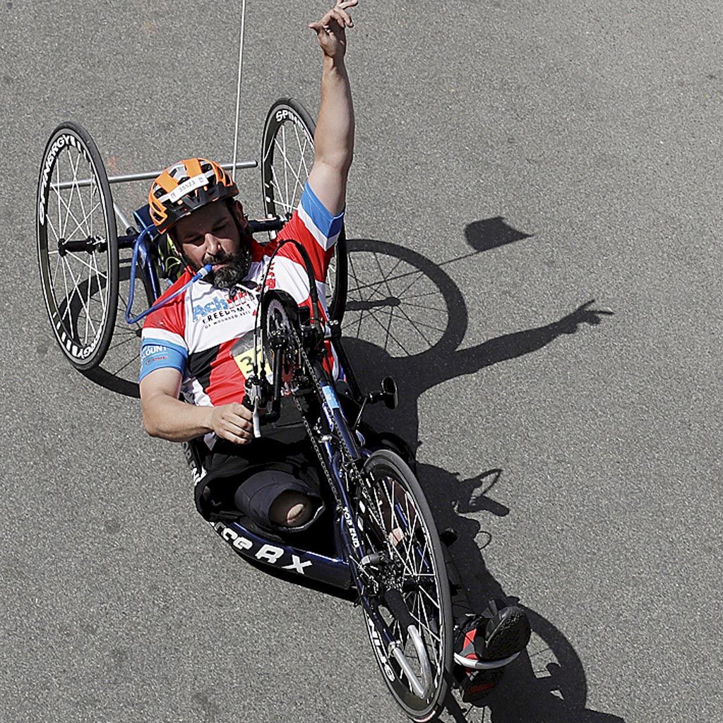 Marc Fucarile, asal Reading, Massachusetts, mengangkat tangan setelah melintasi garis finis di divisi kursi roda putra pada lomba Maraton Boston, Senin (17/4). Fucarile kehilangan kakinya karena terkena ledakan bom pada Maraton Boston 2013.